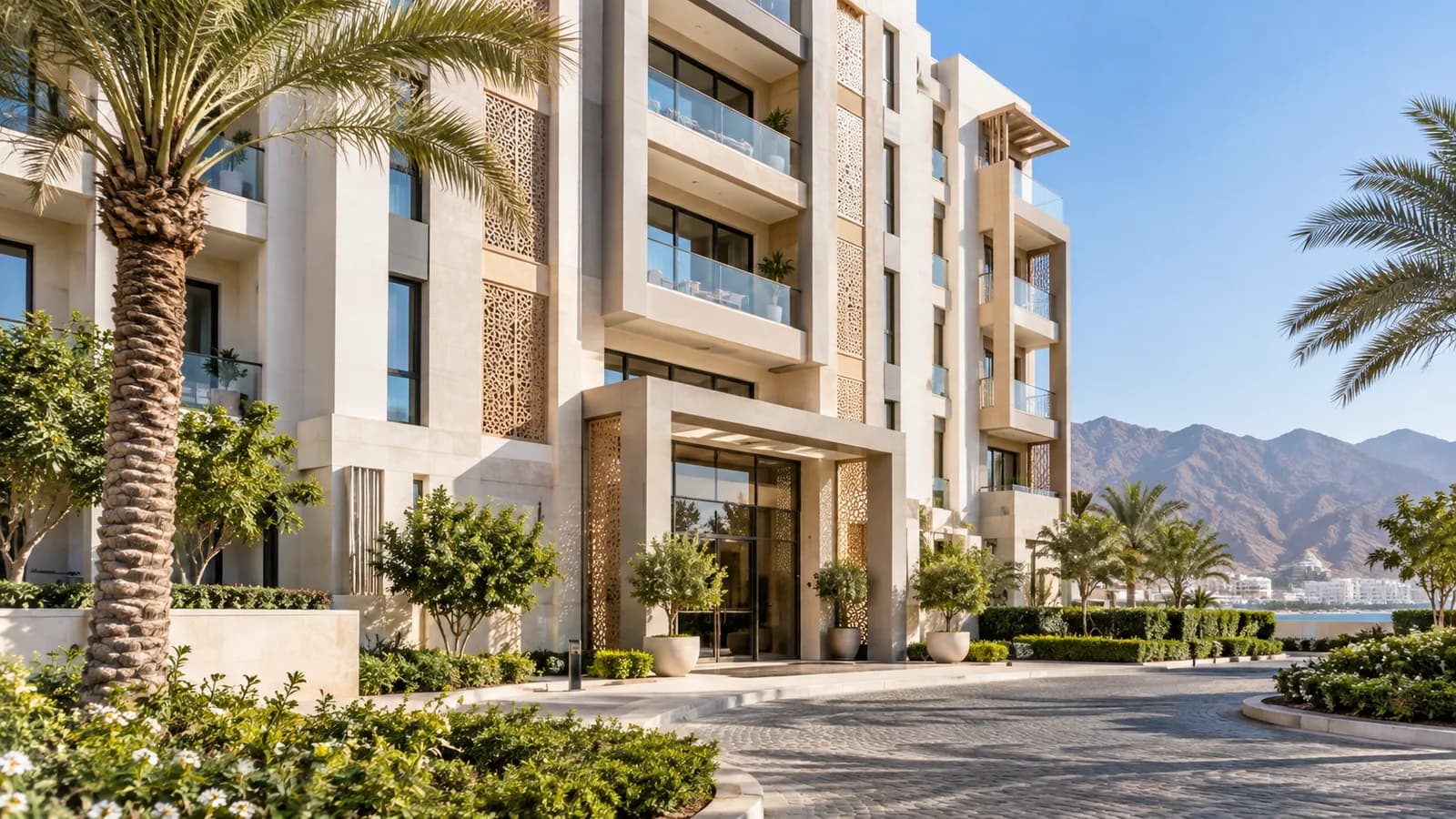 Modern apartment building with landscaped entrance in Muscat